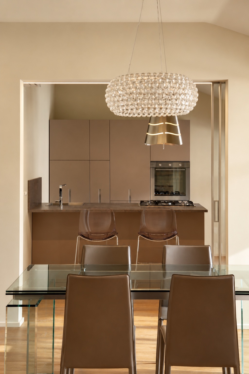 Cucina moderna con penisola vista dal tavolo da pranzo in vetro - Ristrutturazione Casa MLG Bologna