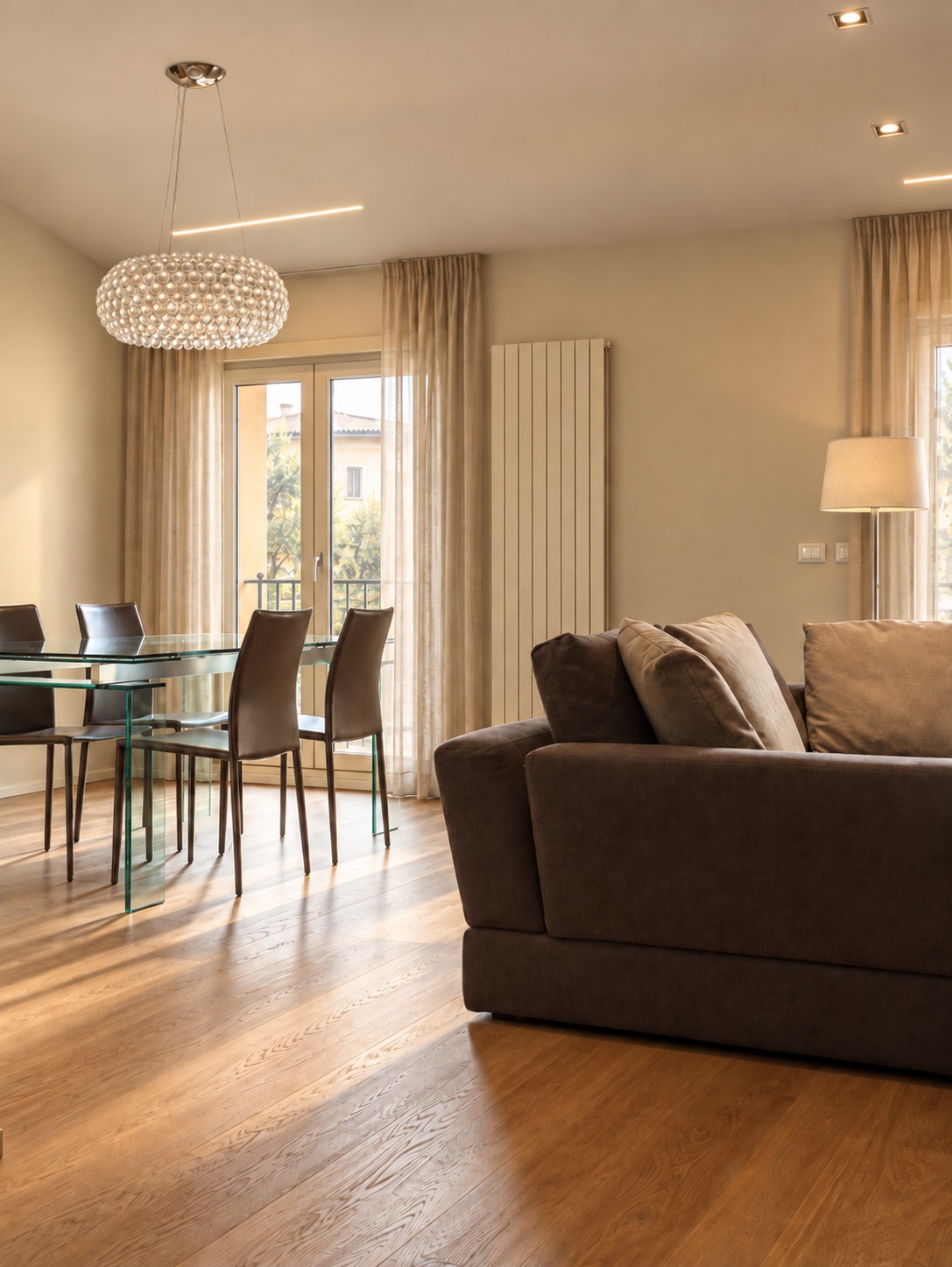 Zona pranzo con tavolo in vetro e lampada da sospensione Caboche Foscarini in open space - ristrutturazione bologna